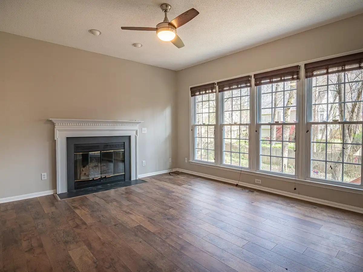 A living room with a ceiling fan and a gas fireplace
