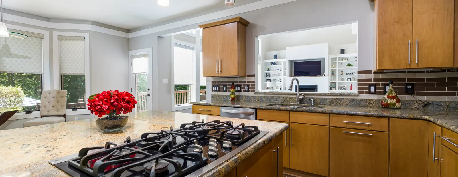A kitchen with a gas cooktop and granite counters