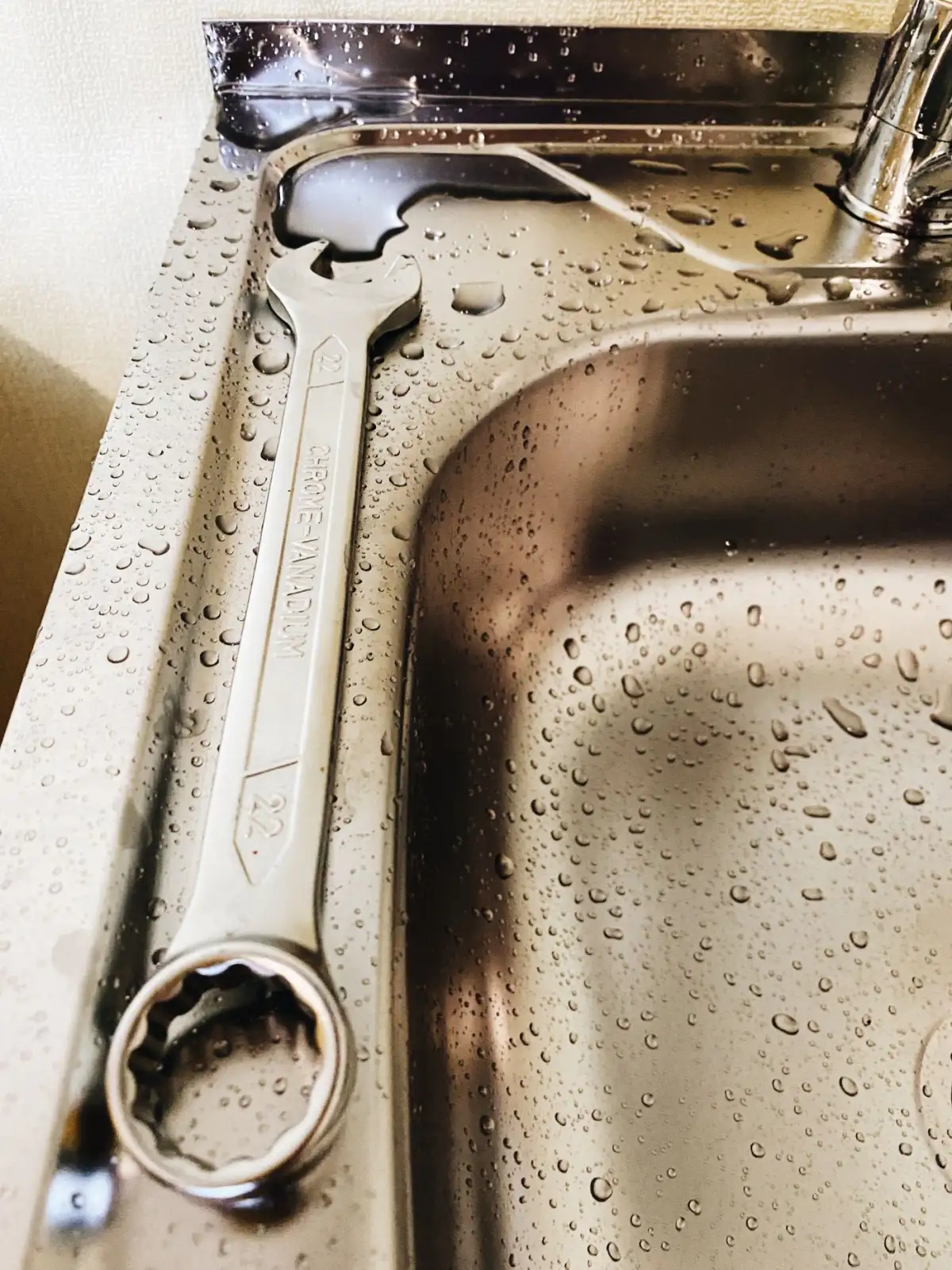 A pipe wrench on a steel surface