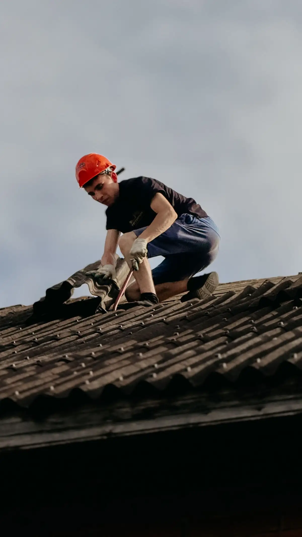 A roofer working along a repaired section