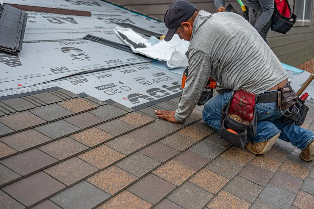 Asphalt shingles being laid and nailed