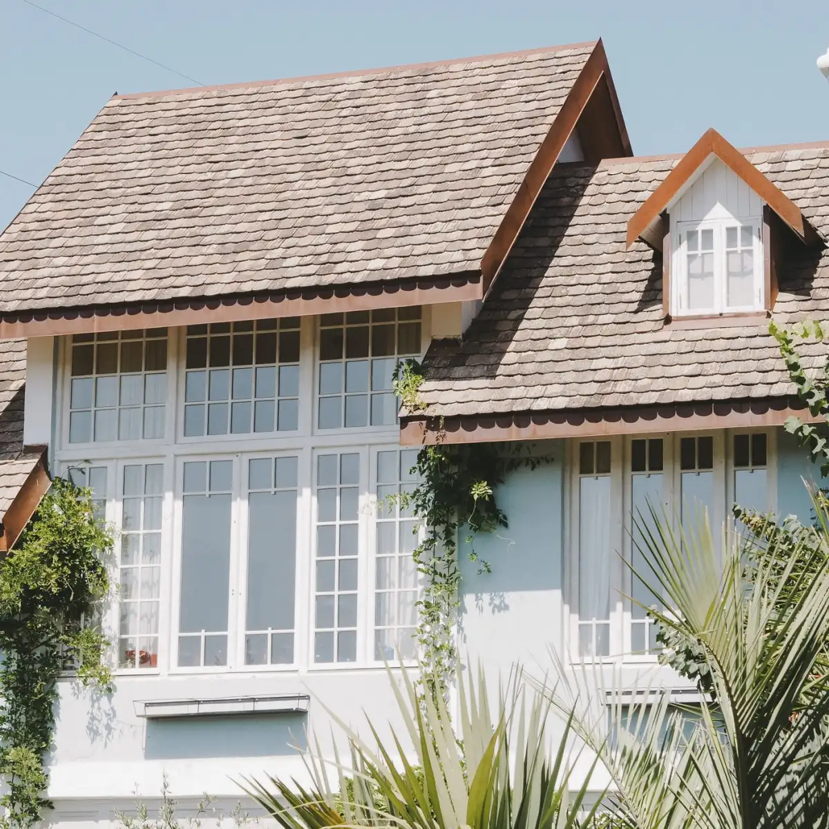 A shingled suburban roof against open sky
